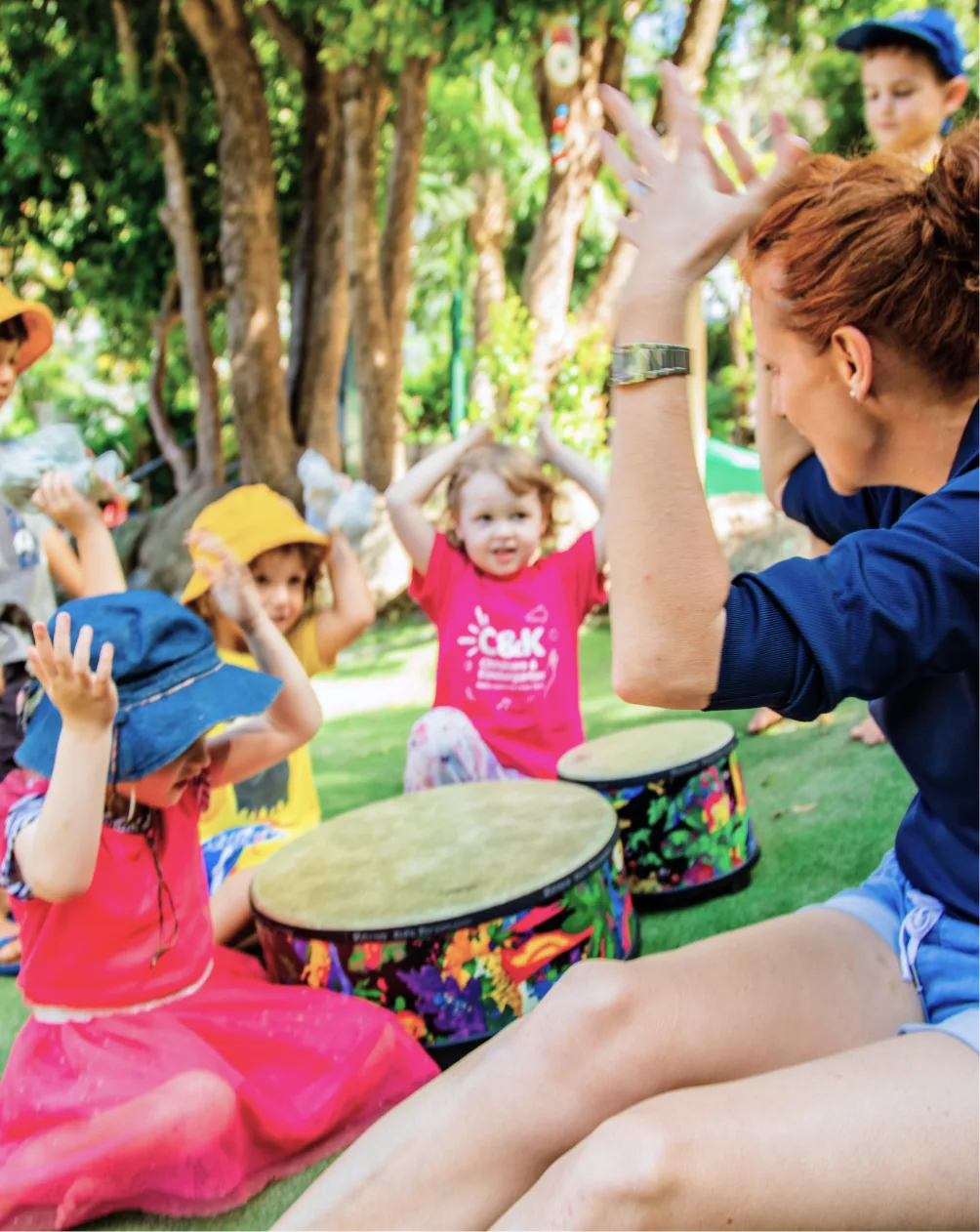 Educator sitting with a group of children sharing instruments