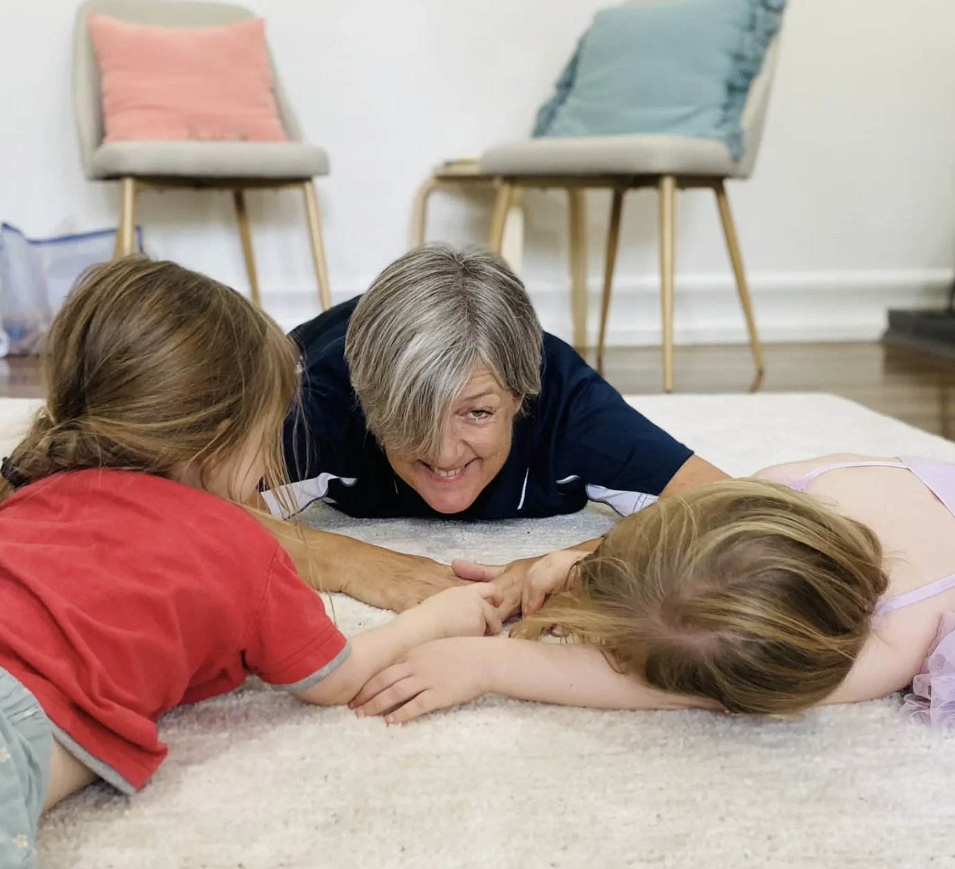 Educator playing with children on the floor in a calm room